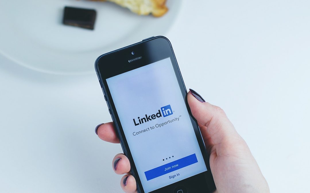 person holding phone with LinkedIn login page