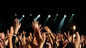 image of hands in the air in a concert